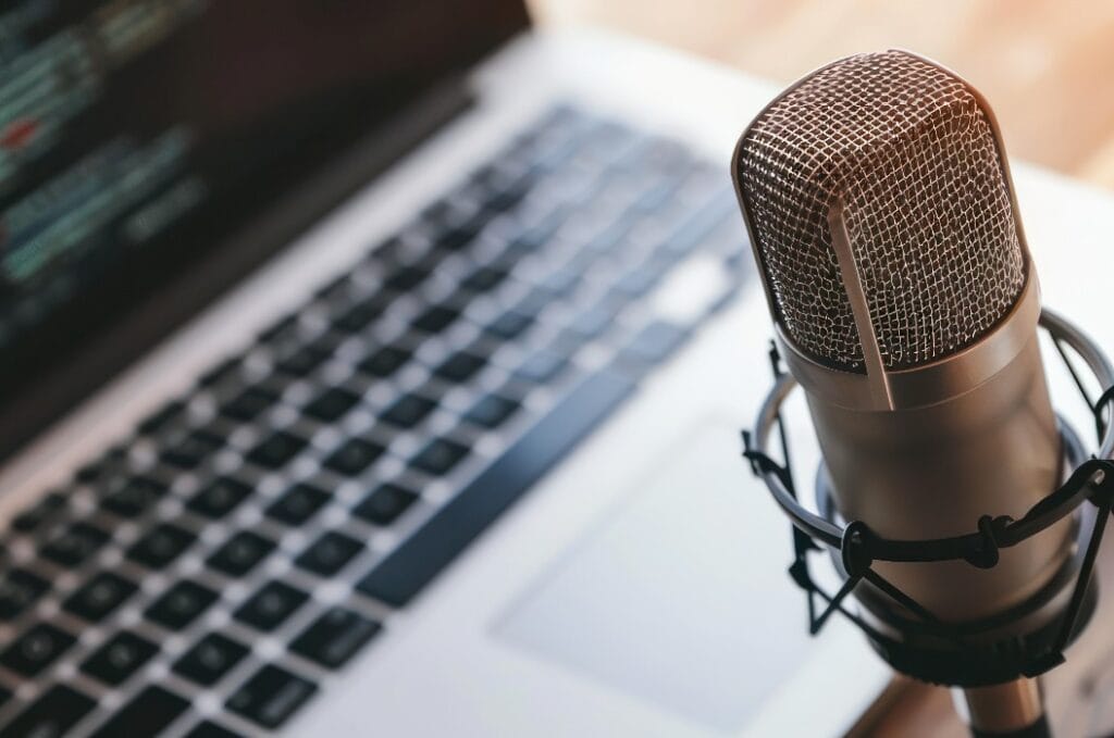 Beleuchtetes Studiomikrofon und Laptop-Setup, ideal für Podcaster und technisch orientierte Sendungen