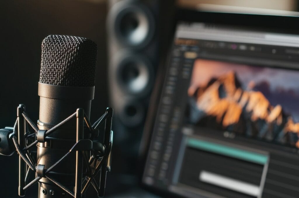 Mikrofon und Laptop für Audioaufnahmen in einer modernen Studioeinrichtung.